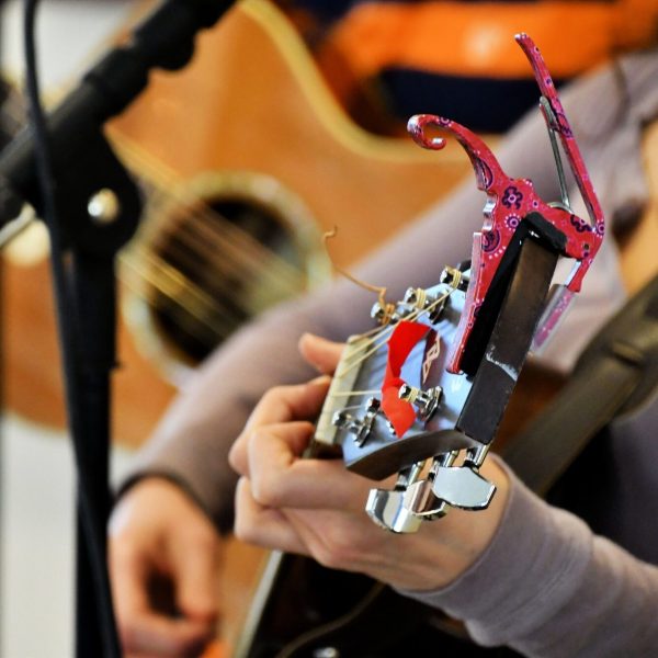 Live music at a festival - Female Playing her guitar while singing. Performing music live on stage.