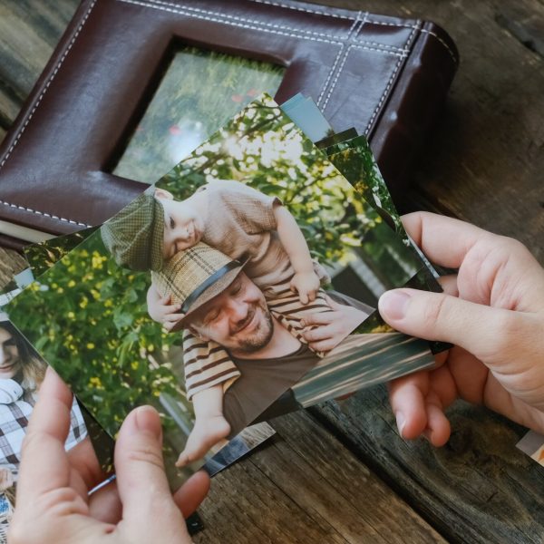 Photo printing, family memories. Woman looks at printed photos for family picture album.